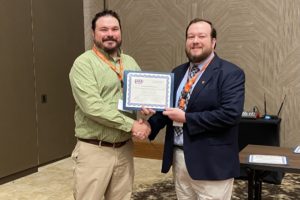 Dr. Tyler Granberry receives the Distinguished Manuscript award.