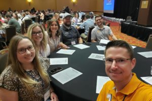 Group of six faculty and staff at a conference.